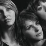 Conduttori di Sanremo sul palco durante una delle serate del festival, con pubblico entusiasta in background.