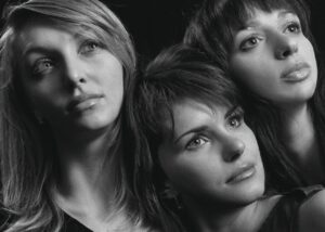 Conduttori di Sanremo sul palco durante una delle serate del festival, con pubblico entusiasta in background.